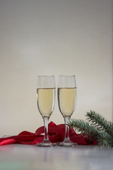 Beautiful composition. Two glasses with champagne, red ribbon and fir branch