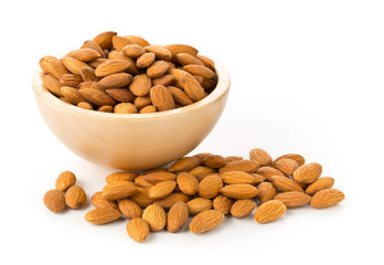 Heap of shelled almond kernels in wooden bowl