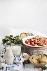 homemade pancakes with strawberries and pineapple on a white plate and a white background, milk vkakane and in a bottle