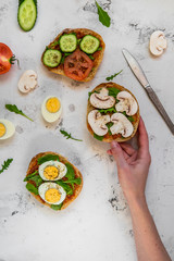 Sandwiches for breakfast. Ciabatta with arugula, egg, mushrooms, cucumbers and tomatoes