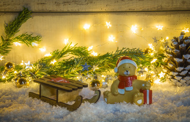 Sleigh in the snow with teddy and fir branch