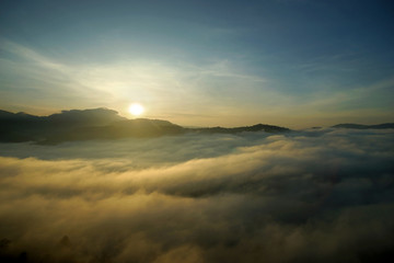 Fototapeta na wymiar sea fog over the hills with sunrise background