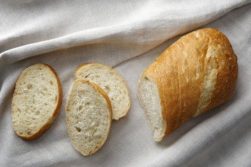 .Cut Italian bread of ciabatta on homespun linen canvas.