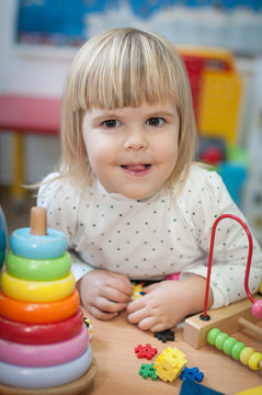 Portrait of little girl having fun at kindergarten, looking at camera