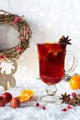 Traditional hot drink at Christmas time. Christmas mulled red wine with spices and fruits. On white snow background