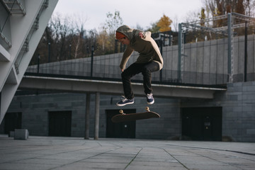 young skateboarder performing jump trick in urban location