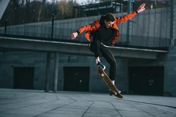 Gordijnen Skateboarder doing jump trick in urban location © LIGHTFIELD STUDIOS