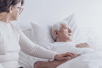 Elderly woman visiting sick husband