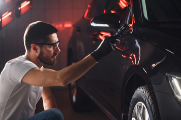 man checks the polishing with a torch