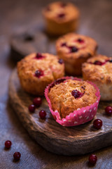cupcake baking with cranberries on wooden background