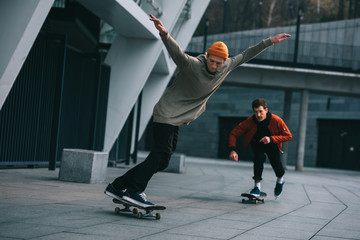 handsome young men riding skateboards in urban location