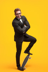 Stylish businessman posing with longboard