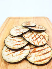 Grilled eggplant on cutting board on isolated white background.