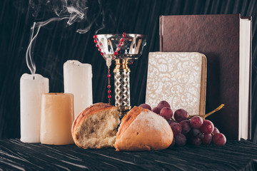 grapes, bread, holy bible, christian cross and chalice for Holy Communion