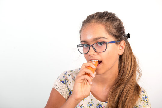 Funny girl with  carrot. Vitamins for teenagers. Vegetabl for healthy eating of children. Positive weight loss. Portrait of  girl with carrot. girl with glasses and carrot 
