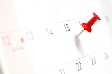 Embroidered red pins on a calendar on the 15th with selective focus - Powered by Adobe