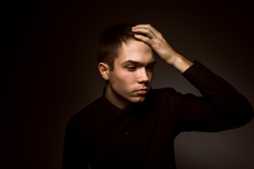 young guy on a dark studio background