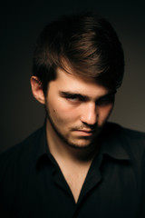 young brunette guy on a dark background
