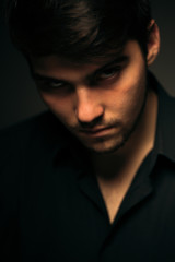 young brunette guy on a dark background