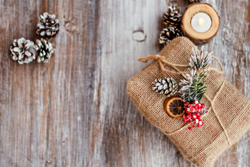 Christmas composition. Christmas gift, cones and candleon vintage wooden background. Top view, flat lay, copy space, Place for text