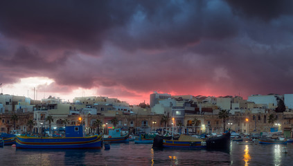 Obraz premium Gloomy sunset at fishing village Marsaxlokk, Malta