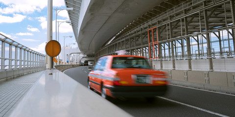 Motion blurred red taxi on highway in Tokyo