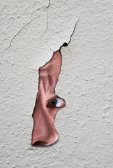 Auge, das durch ein Loch in der Wand späht