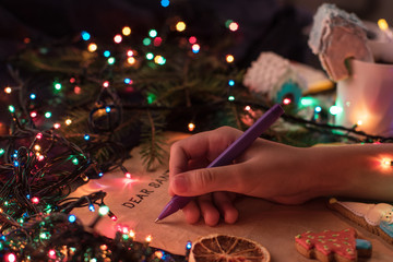 Boy's hand closeup, writing a letter to Santa, cristmas background