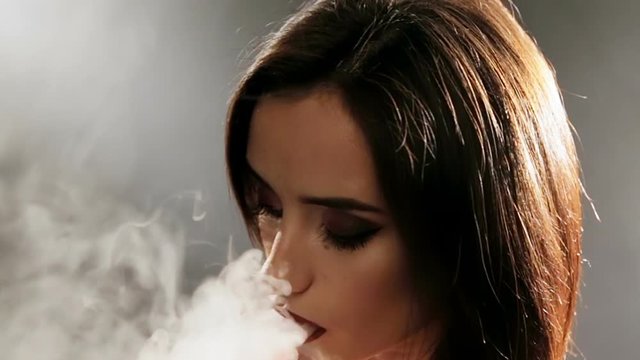 Beautiful woman vaping with electronic cigarette