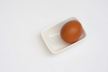 Top view of fresh egg in white small bowl isolated on white background. (Selective focus)