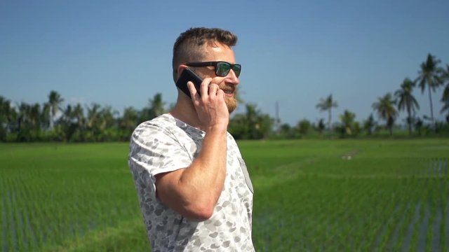 Happy man talking on cellphone and walking in country, super slow motion 240fps
