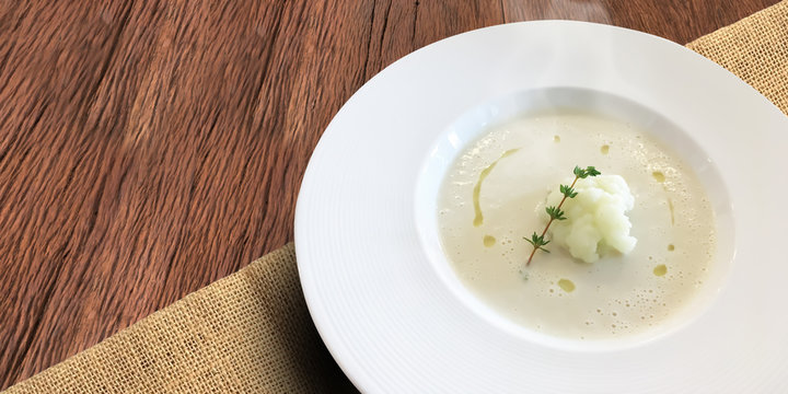 Fresh homemade authentic delicious Cauliflower Soup on wooden textured table.