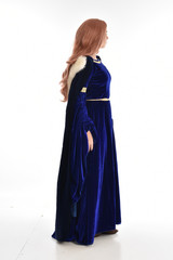 full length portrait of girl wearing long blue velvet gown and fur lined cloak, standing pose...