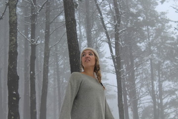 GIRL IN SNOW COVERED PINE FOREST