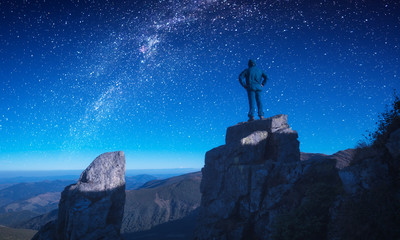 Man standing on a edge against night sky