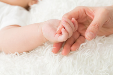 Fototapeta 赤ちゃんと手をつなぐ女性
 obraz