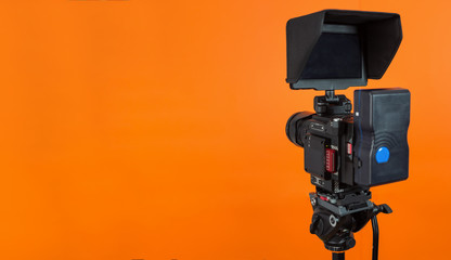 Professional video camera on vivid color background making contrast