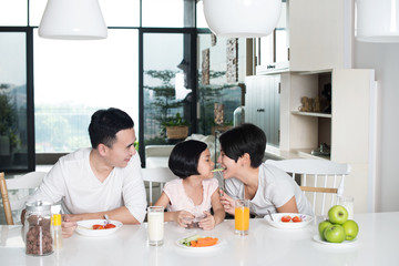 Young Asian family eating together at home.