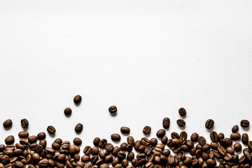 Brown coffee beans on the white background. Choice of the best sort and quality coffee. Empty place for a text. Mock up for seasonal offers as advertising or web background, or other ideas.