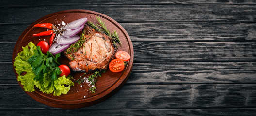 Grilled Steak, with Vegetables. Pork, veal, meat. On a wooden background. Top view. Free space for text.