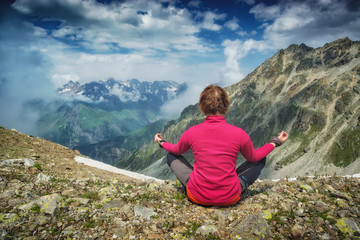Naklejka na ściany i meble Woman meditating on the rocky hill