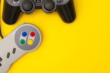 Retro computer gaming controllers on a bright yellow background