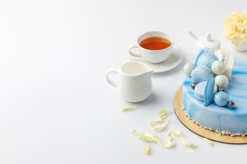 blue tasty cake on chopping board with cup of tea isolated on white