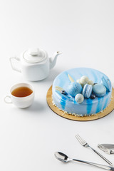 blue tasty cake on chopping board with tea isolated on white
