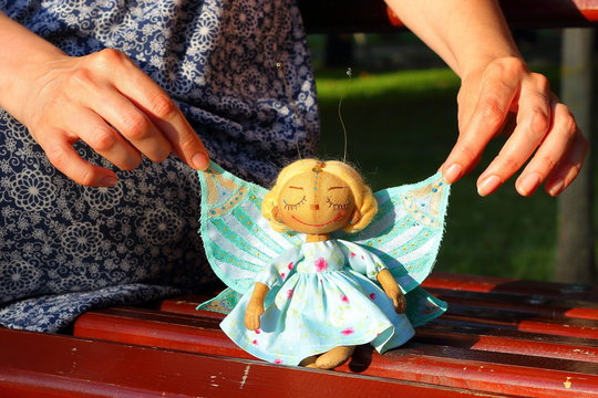 Little delicate handmade fabric textile doll girl butterfly with eyes closed with pleasure blond hair and blue wings in hand