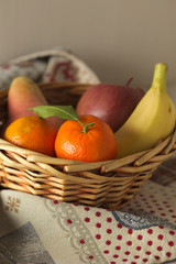 Cesto di frutta con mandarini, pera, mela e banana