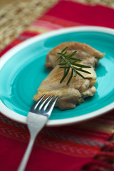 Pollo cotto in padella con rametto di rosmarino