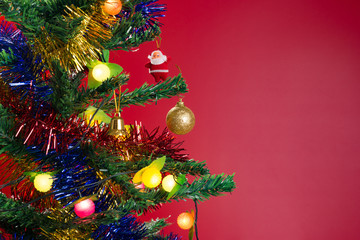 fir tree with Christmas decorations on red