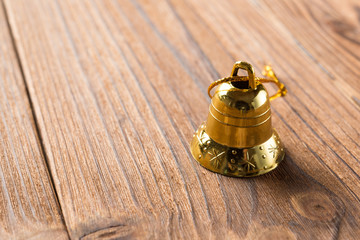 Fototapeta na wymiar golden Christmas bell on a wood background