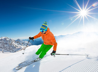 Skier skiing downhill in high mountains